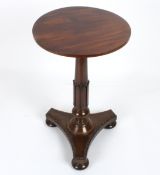 An early 19th century mahogany wine tablethe plain circular top supported on a tapering carved