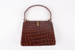 A 1930's crocodile handbagof slightly tapered form, the brown coloured bag with gold coloured