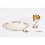 A Continental silver christening egg cup set
comprising an egg cup, spoon and oval tray, with beaded