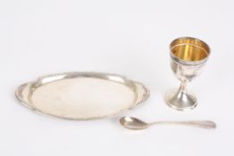 A Continental silver christening egg cup setcomprising an egg cup, spoon and oval tray, with beaded