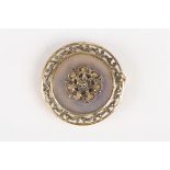 An early 20th century silver gilt and agate brooch
of circular form mounted with a central floral