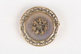 An early 20th century silver gilt and agate broochof circular form mounted with a central floral
