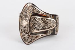 An early 20th century Oriental tortoiseshell and white metal banglewith hinged clasp of buckle