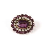 An amethyst colured glass and seed pearl oval cluster brooch set with large central oval amethyst