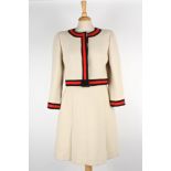 A cream Chanel wool skirt suit
the jacket with round neck and black and red trim to edges and cuffs,