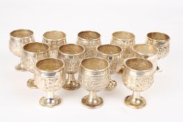 A set of twelve Indian white metal small gobletsmarked 'Sterling Silver', decorated with embossed