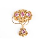 A Victorian gilt metal pendant brooch
set with foiled paste stones in an elaborate scrolled mount