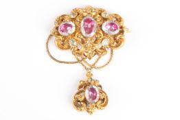 A Victorian gilt metal pendant broochset with foiled paste stones in an elaborate scrolled mount
