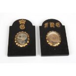 A pair of 19th century memorial plaques
formed as small black marble headstones, each crested with