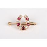 A ruby and diamond horse shoe brooch
with alternating pear shaped rubies and circular diamonds,