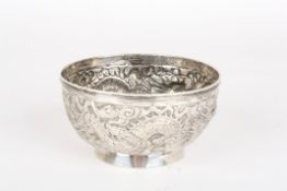 A 19th century Chinese white metal embossed bowlthe body finely embossed with two dragons chasing a