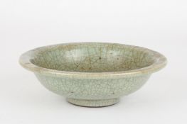 A 19th century Chinese celadon glaze shallow dishof plain form with crazed mutton fat body and