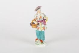 A mid 20th century Meissen porcelain figure of an oriental manstood holding a brightly coloured