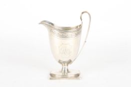 A George III silver helmet shaped cream jughallmarked London 1792, with engraved monogram cartouche