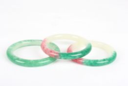 Three modern jade banglestwo with pink, another green, 8cmCondition: All in fair condition