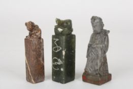 Three early 20th century carved jade and soapstone sealsone formed as a scholar, the other two as