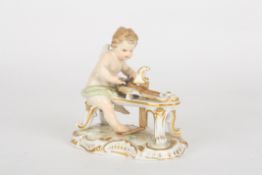 An early 20th century Meissen porcelain figure of a cherubseated at a scrolled white and gilt