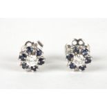 A pair of 18ct white gold, sapphire and diamond cluster earrings
of daisy head form, set with