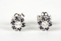 A pair of 18ct white gold, sapphire and diamond cluster earringsof daisy head form, set with