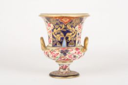 An early 19th century Derby Imari campagna urndecorated with pink flowers, leaves and scrolls on