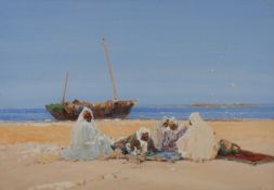 An early 20th century Middle Eastern or African beach scenewith figures sitting on rugs on a beach,