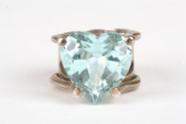 A large heart shaped aquamarine dress ringset in a heavy white metal mount, stone measuring 17 x 18