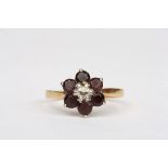 A garnet and diamond daisy cluster ring
set in 18ct gold, Size P 1/2.Condition: Good condition