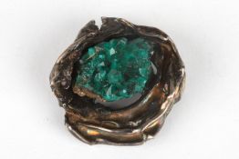 An unusual natural emerald crystal broochset in a naturalistic white metal mount, 3.5 cm wide.