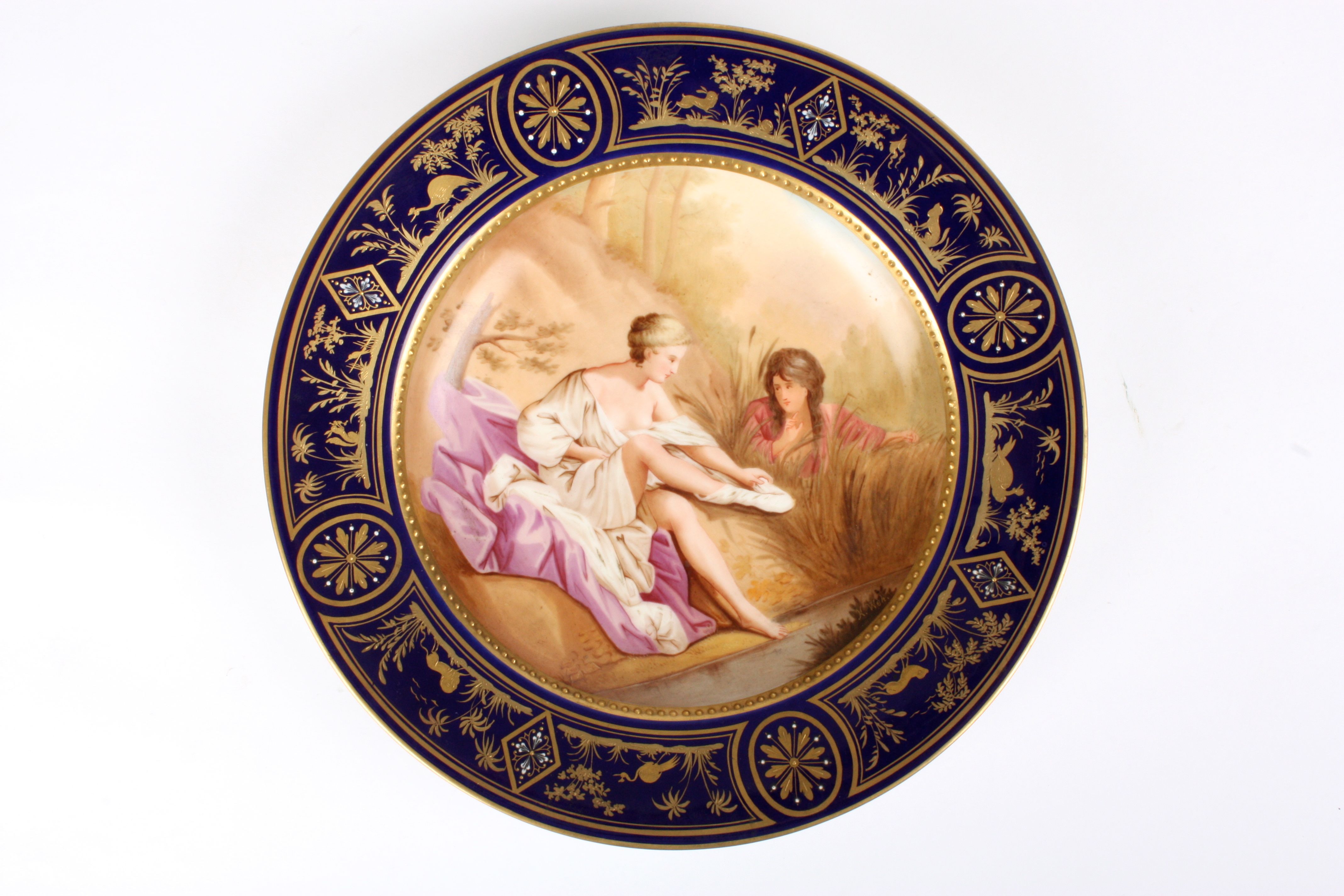 A late 19th century Vienna porcelain plate
decorated with a scene of a young lady changing and