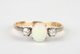 An opal and diamond three stone ringset with central oval opal of good colour, flanked by small