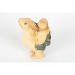 An early 20th century Japanese carved ivory netsuke
formed as a figure of a man riding on the back
