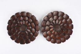 A pair of carved treen chrysanthemum flower head roundelsstamped with a bird and four acorns, 25 cm