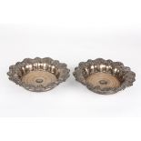 A large pair of silver plated bottle coasters
the lobed rims decorated with grapes and vine