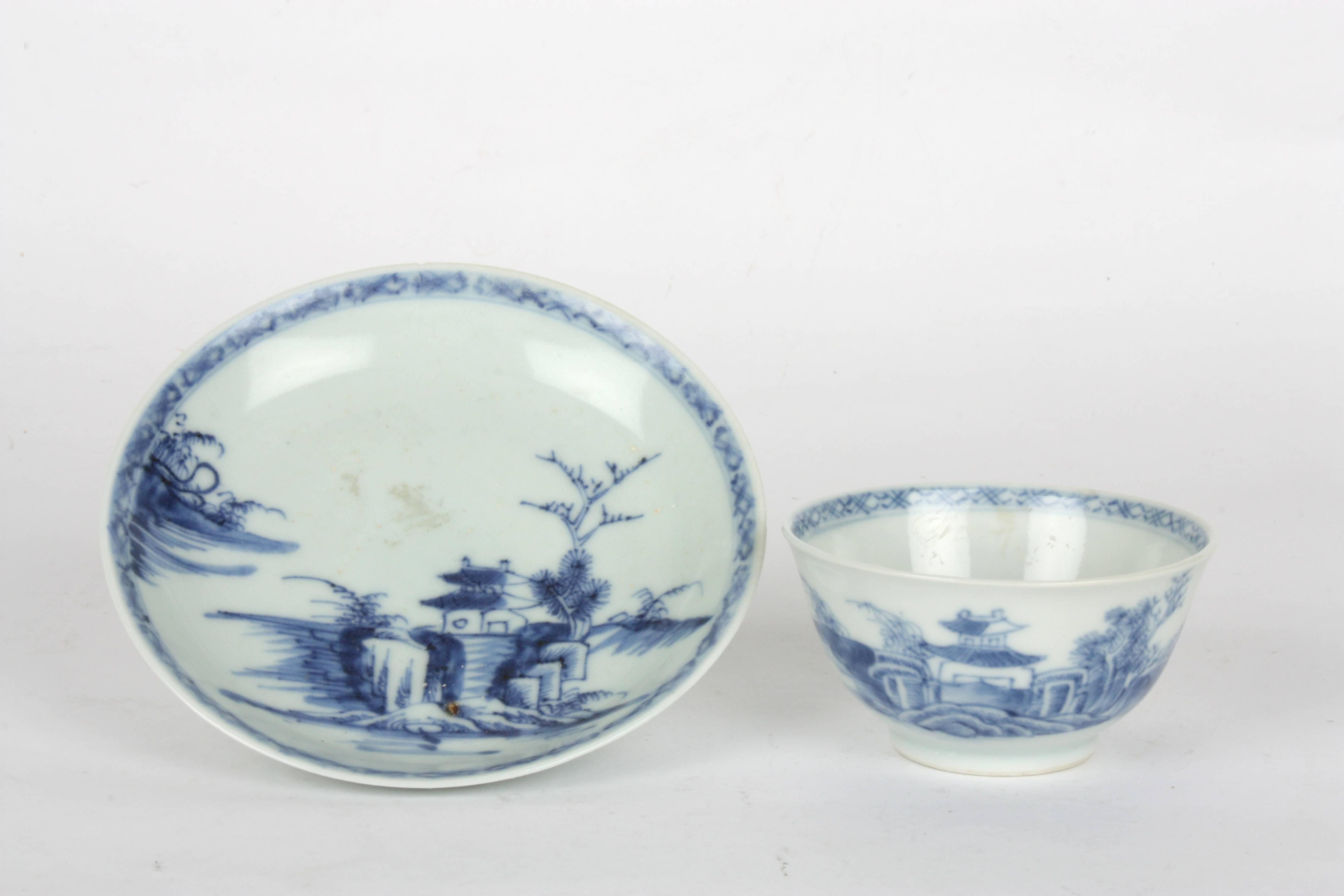 A Nanking Cargo blue and white porcelain tea bowl and saucer
painted with a landscape scene with