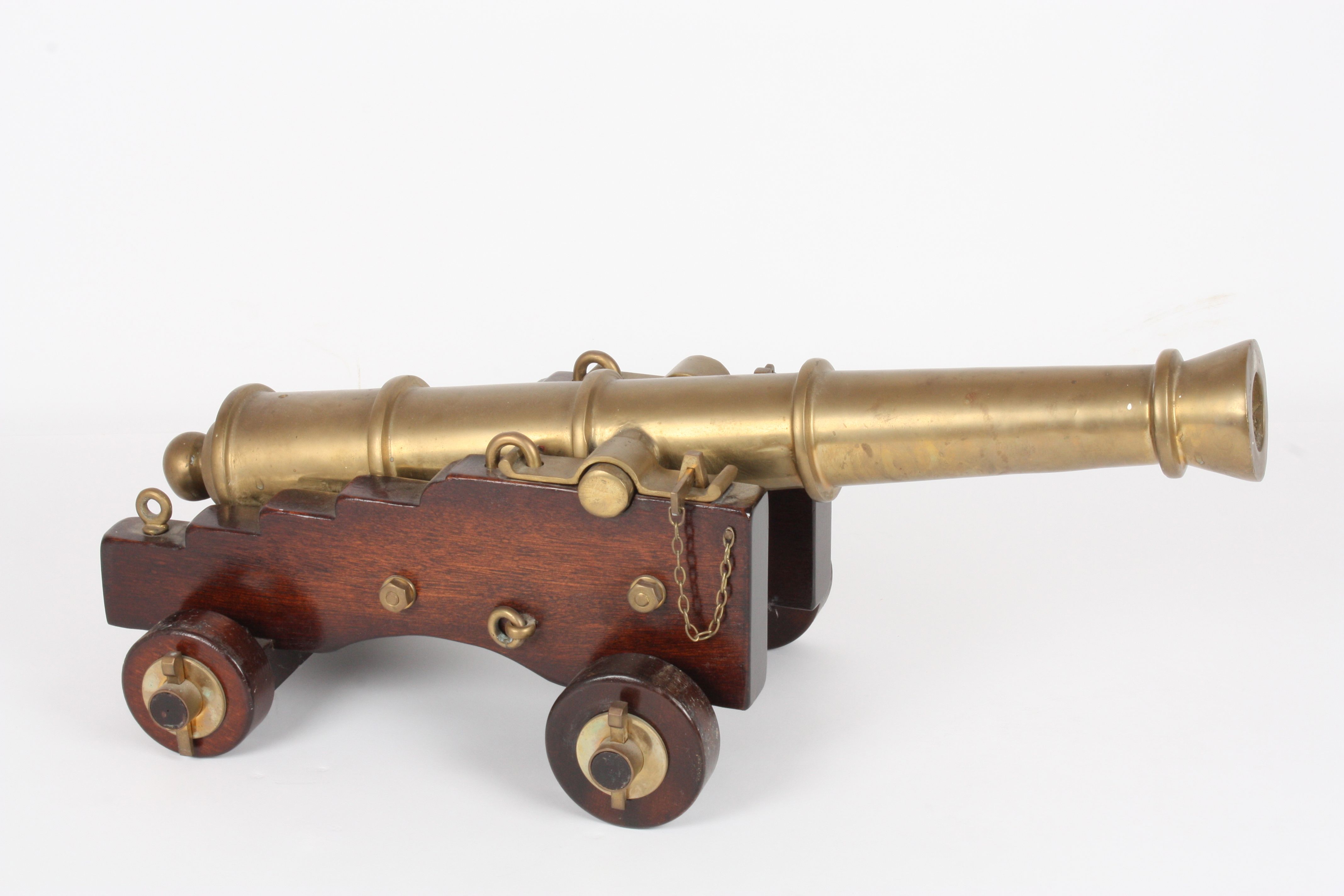 A 19th century brass and wood model of a cannon
with 74cm tapering barrel, mounted on a stepped