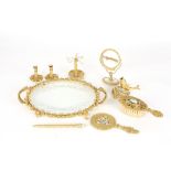 A 1950s gilt metal dressing table set
comprising a tray, hand held mirror, small standing mirror,