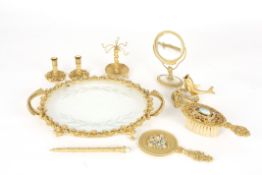 A 1950s gilt metal dressing table setcomprising a tray, hand held mirror, small standing mirror,