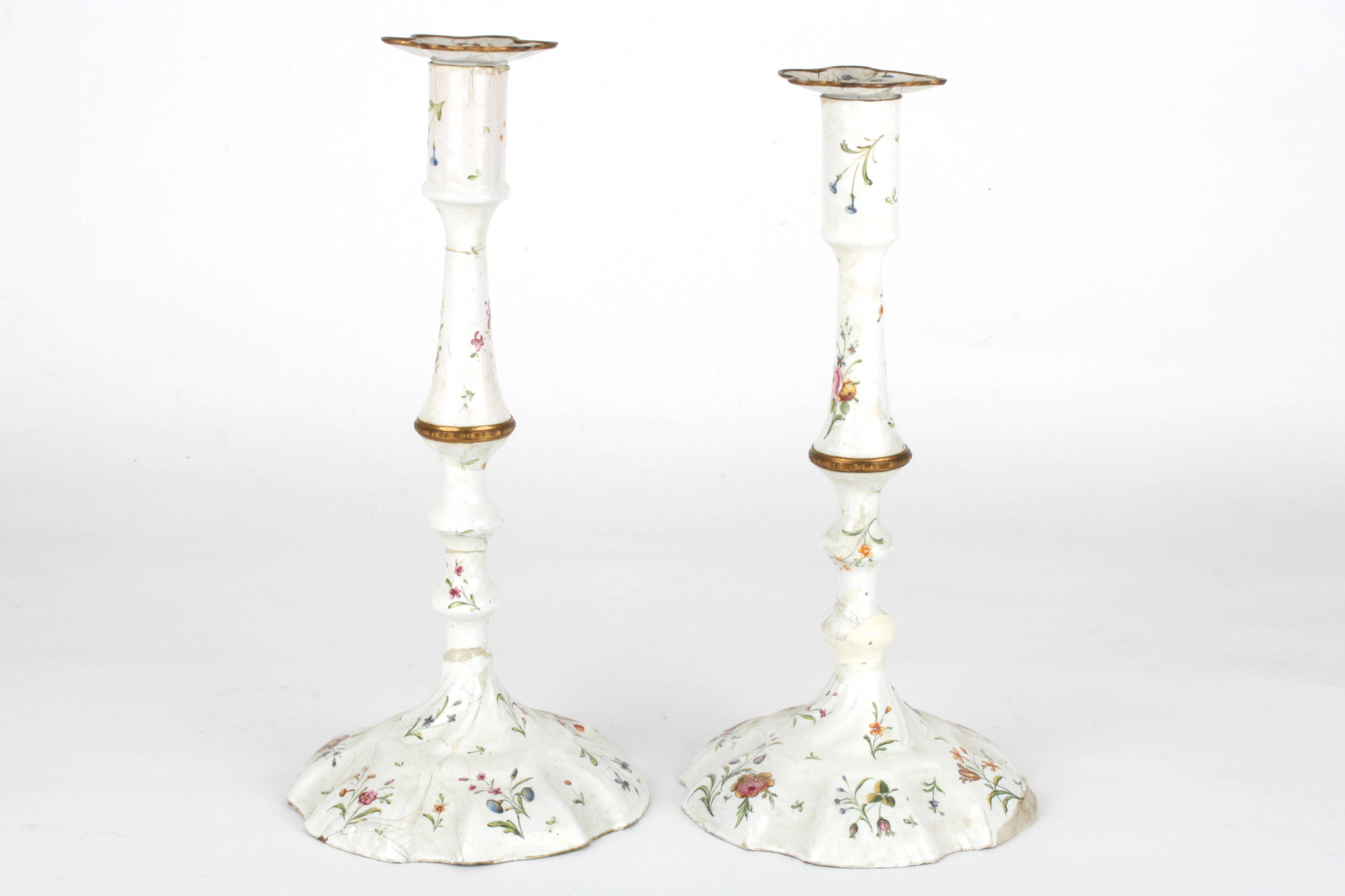 A large pair of 18th Century English enamelled metal candlesticks
decorated with vignettes and