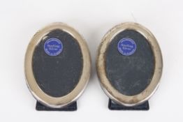 A small pair of modern Sterling silver oval photograph frameswith Sheffield hallmarks, and blue