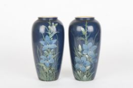 A pair of Royal Doulton Faience vases by Florence Barlowdecorated with flowers and leaves on a