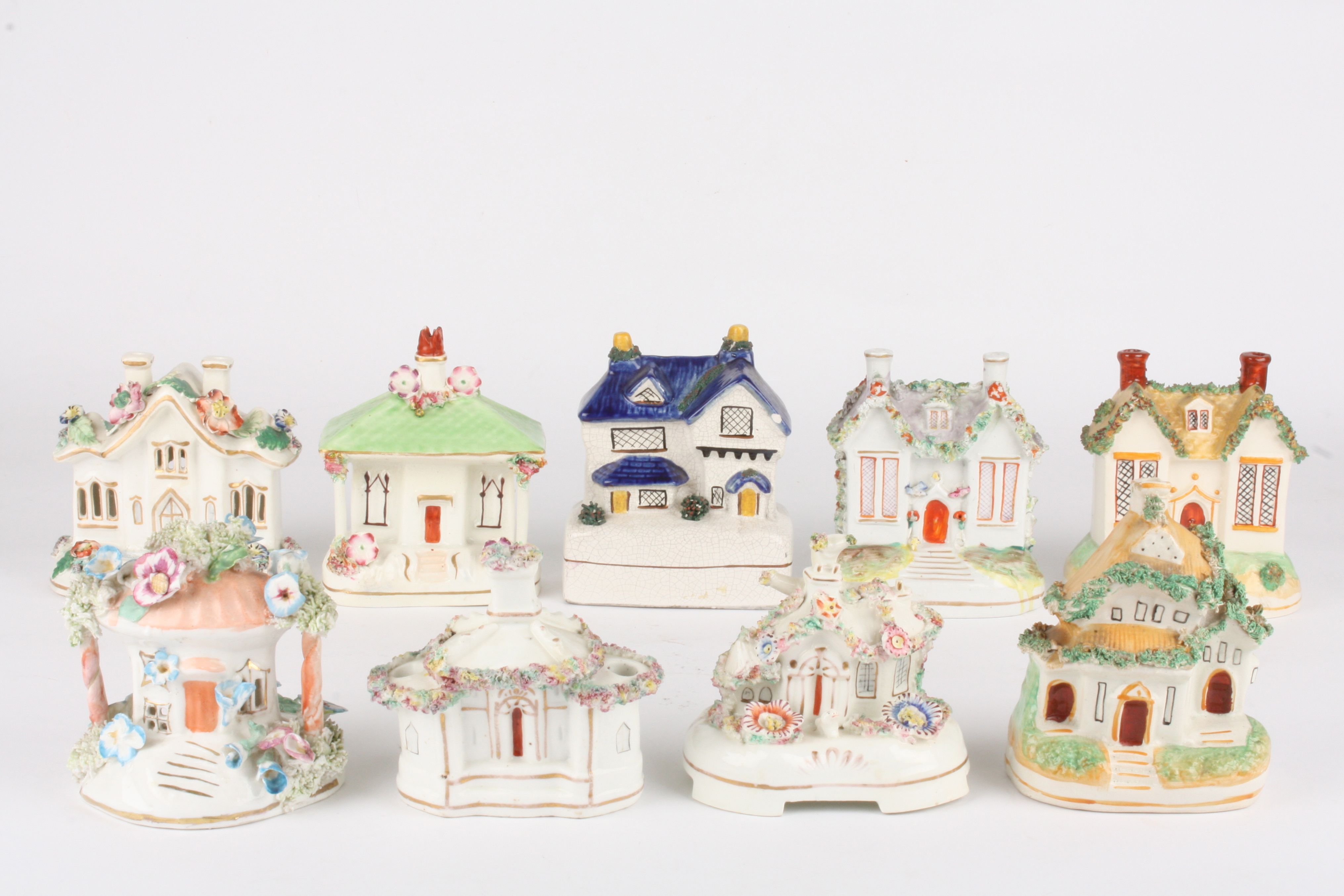 A collection of eight Victorian Staffordshire pottery pastille burner cottages
all with encrusted