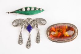 An early 20th century silver and enamel leaf broochtogether with a Baltic amber and silver brooch