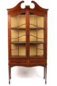 An Edwardian mahogany display cabinetthe two glazed front doors opening to reveal two shelves above