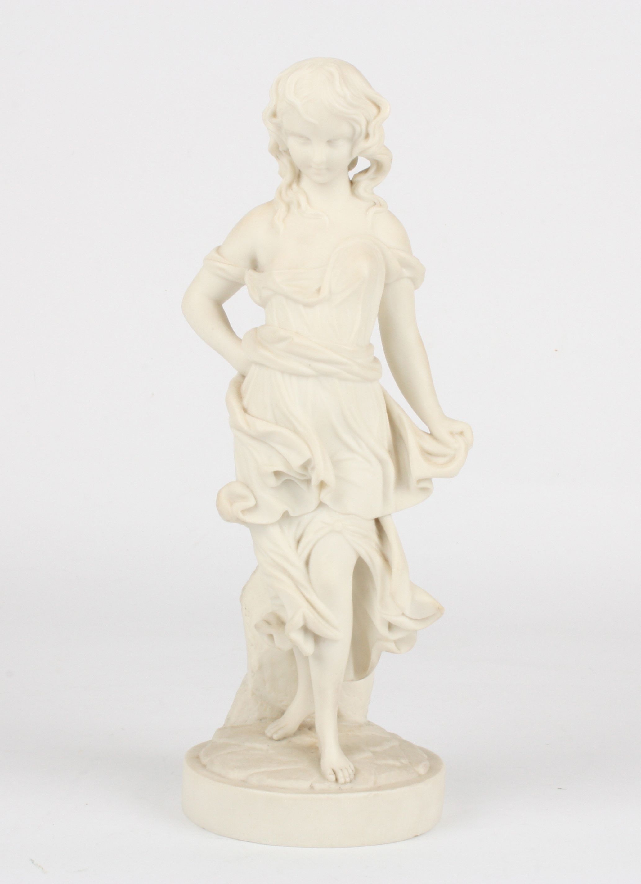 A Victorian style Parian figure of a young girl
stood wearing a flowing robe and supported on a