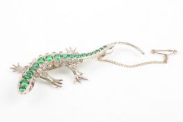 A costume jewellery lizard broochwith a row of green paste stones down her back, flanked by rows of