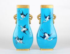 A large pair of Victorian Minton turquoise glazed bottle vasespainted with cranes in flight, with