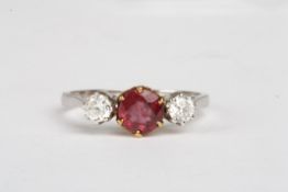 An 18ct white gold, diamond and ruby three stone ringthe central ruby flanked by diamonds