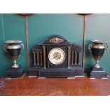 DECORATIVE BLACK SLATE MANTEL CLOCK WITH BRASS COLUMNS, ORMOLU MOUNTS AND ENAMELLED DIAL.