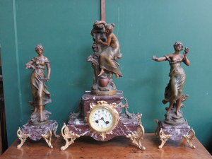ART NOUVEAU FRENCH STYLE SPELTER FIGURE FORM CLOCK AND GARNITURE SET WITH ENAMELLED DIAL AND ORMOLU