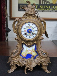 FRENCH STYLE GILT METAL MANTEL CLOCK WITH HANDPAINTED PORCELAIN DIAL AND PANEL,